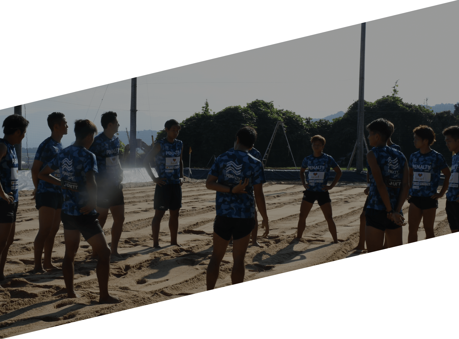 砂の上でミーティングするビーチサッカー選手