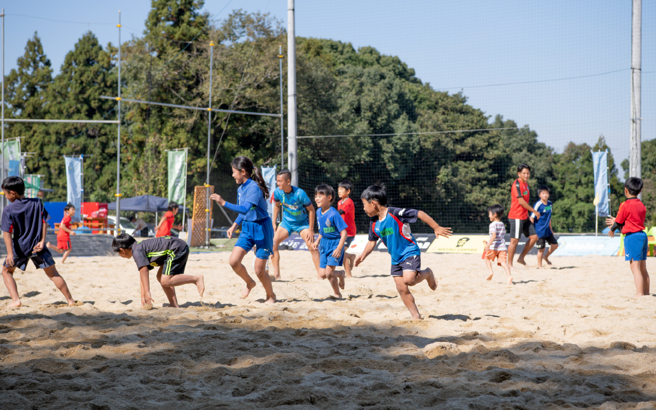 ビーチコートで子どもたちにサッカーを教える様子